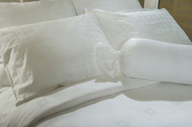 Yatağın üzerinde yer alan konforlu yumuşak yastık.