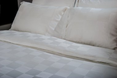 Yatağın üzerinde yer alan konforlu yumuşak yastık.