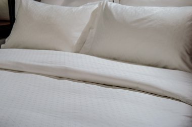 Yatağın üzerinde yer alan konforlu yumuşak yastık.