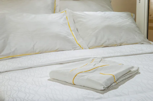 Składany szlafrok na hotelowym łóżku. — Zdjęcie stockowe