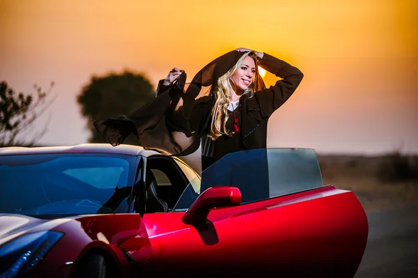 Manera árabe vestida mujer yang posando en coche rojo en el desierto . — Foto de Stock