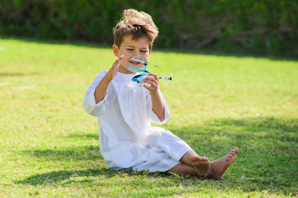 Menino árabe brinca com helicóptero de brinquedo — Fotografia de Stock