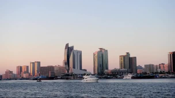 Motorboot fährt allein Dubai Creek bei Sonnenuntergang. — Stockvideo