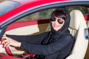 Arapça bir şekilde çölde kırmızı araba poz yang kadın giyinmiş.