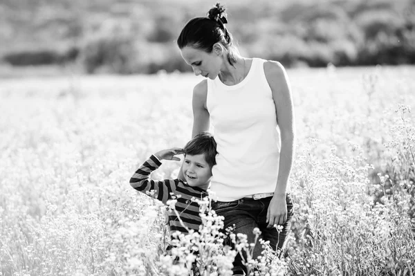 Black and white picture of mother and son in the field. — Stock Photo, Image