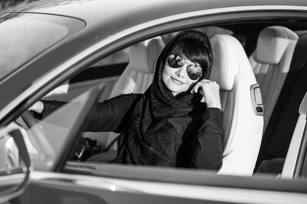 Façon arabe habillé femme yang posant dans la voiture dans le désert . — Photo