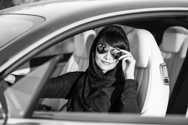 Façon arabe habillé femme yang posant dans la voiture dans le désert . — Photo