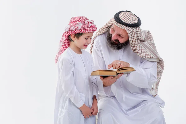 Père arabe enseignant à lire le Coran son fils . — Photo