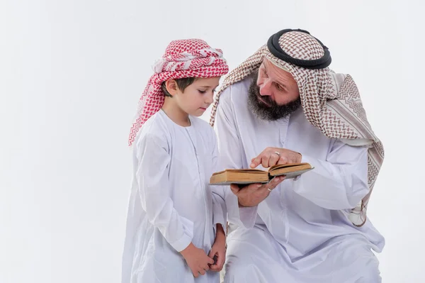 Arap baba oğlu Kur'an okumak için öğretim. — Stok fotoğraf