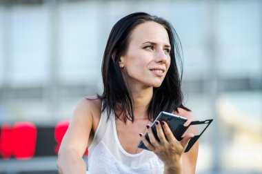 Yang ve güzel modern iş kadın pozlar ile akıllı telefon açık.