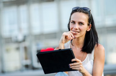 Genç ve güzel bir modern kadın pozlar tablet bilgisayar ile açık.