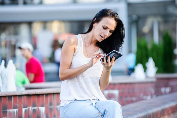 Yang och vackra moderna business woman poser utomhus med smart telefon. — Stockfoto