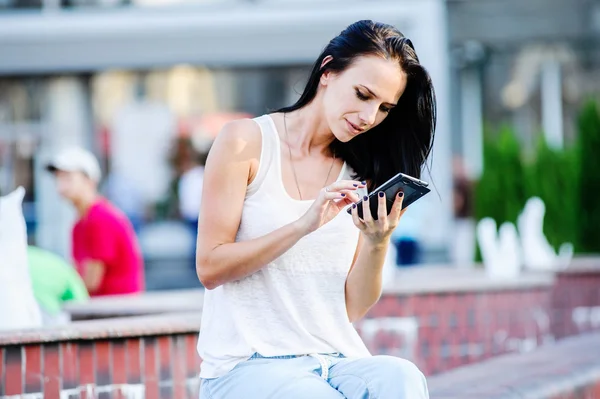 Yang y hermosa mujer de negocios moderna posa al aire libre con teléfono inteligente . — Foto de Stock