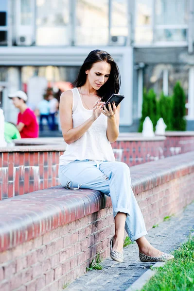 Yang y hermosa mujer de negocios moderna posa al aire libre con teléfono inteligente . — Foto de Stock