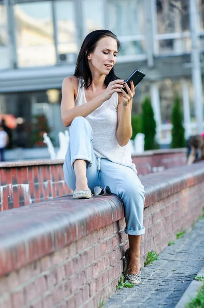 Yang och vackra moderna business woman poser utomhus med smart telefon. — Stockfoto