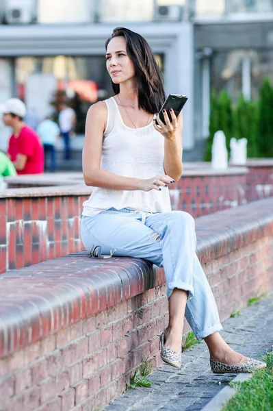 Yang och vackra moderna business woman poser utomhus med smart telefon — Stockfoto