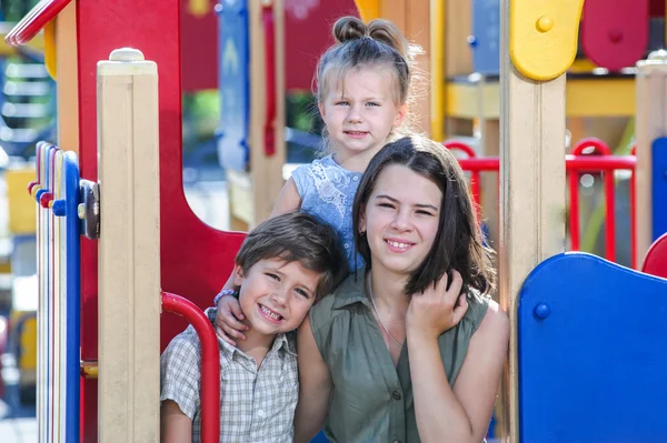 Tre olika åldern barnen poserar på lekplats. — Stockfoto