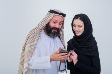 Cep telefonu ile Çift oynamak portre Arapça şekilde giyinmiş.