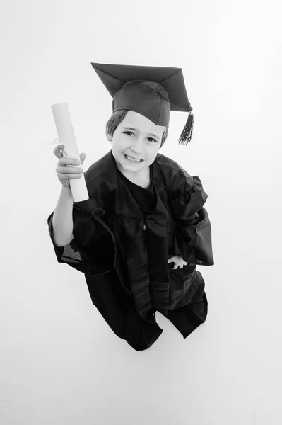 Mały chłopiec, właśnie ukończył student, patrząc w górę — Zdjęcie stockowe