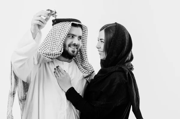 Middle eastern way dressed young couple playing with toy plane. — Stock Photo, Image