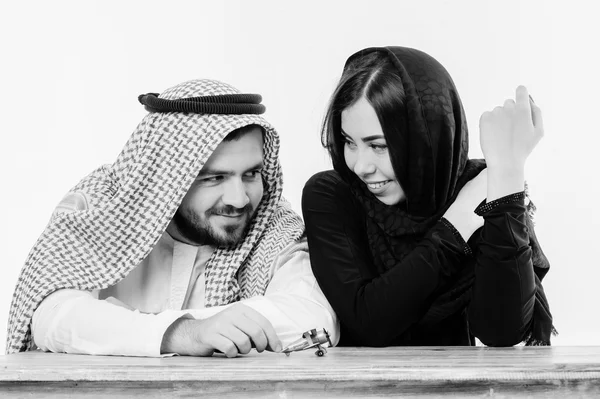 Middle eastern way dressed young couple playing with toy plane. — Stock Photo, Image