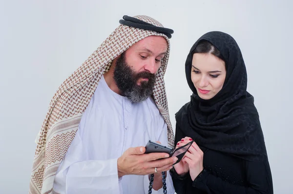 Retrato de manera árabe vestida pareja jugar con el teléfono móvil . — Foto de Stock