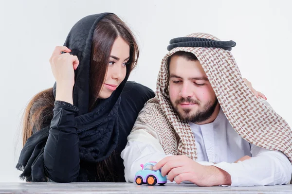 Middle eastern way dressed yang souple playing with toy car. — Stock Photo, Image