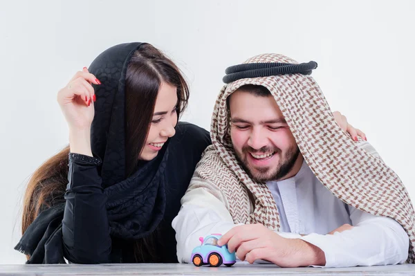 Middle eastern way dressed yang souple playing with toy car. — Stock Photo, Image