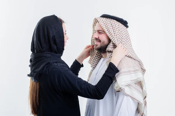 Árabe esposa fixando seu marido cabeça cachecol . — Fotografia de Stock