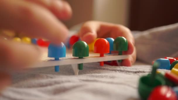 Küçük çocuk çok renkli çocuk mozaik iğneler ile oynuyor — Stok video