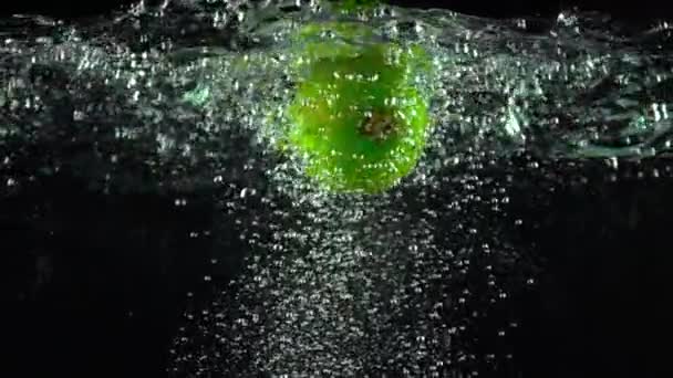 Whole lime rotating under water super slow motion shot. Black background — Stockvideo