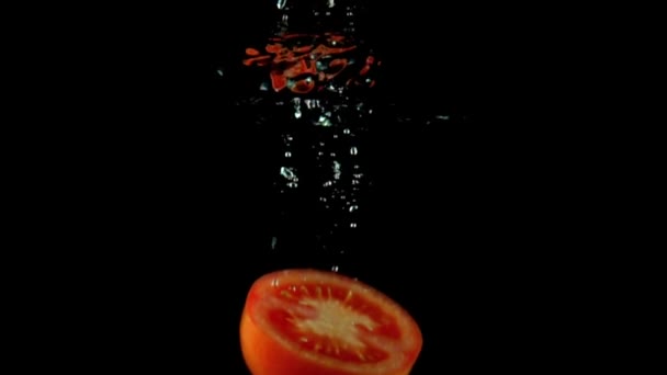 Metà del pomodoro rosso cade sotto l'acqua super slow motion shot. Fondo nero — Video Stock