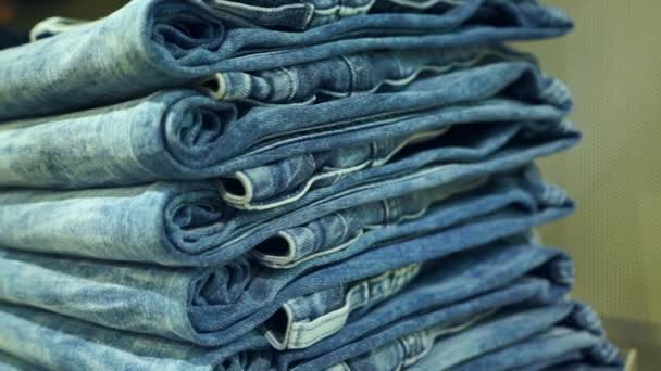 Tumpukan jeans biru baru di toko pan shot — Stok Video