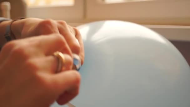 A rapariga amarra o balão azul de hélio. Fechar tiro — Vídeo de Stock