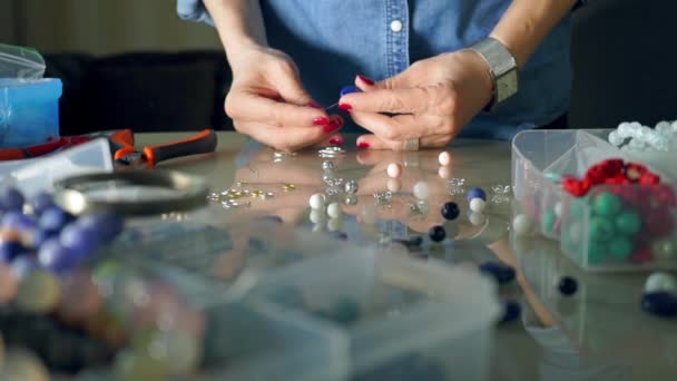 Jonge vrouw maken van parel oorbellen in haar atelier — Stockvideo