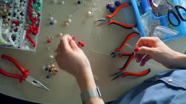 Χώρο εργασίας του καλλιτέχνη αξεσουάρ κάνοντας σκουλαρίκια χάντρα, θέα από ψηλά — Αρχείο Βίντεο
