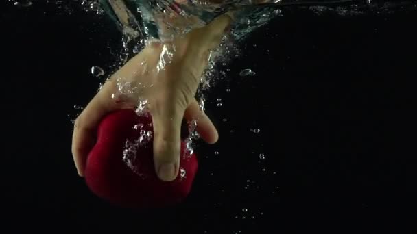 Hombre mano alcanza y agarra manzana roja flotando bajo el agua super cámara lenta disparo — Vídeos de Stock