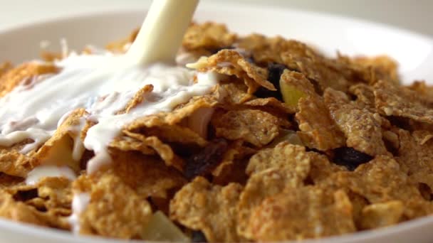 Super slow motion video of milk being added to corn flakes on white plate — Stock Video