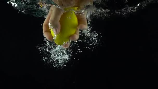 Main de l'homme atteint et attrape citron flottant sous l'eau tir au ralenti super — Video