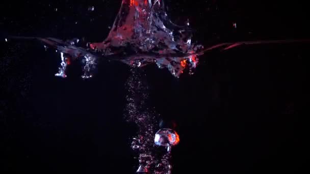 Apple falling in water super slow motion video against dark background — Stock Video