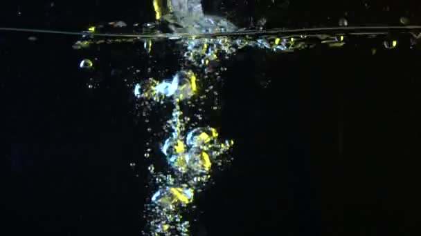 Limone cadere in acqua super slow motion colpo contro sfondo nero — Video Stock