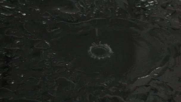 Супер медленный снимок капли воды, падающей на влажную стеклянную поверхность — стоковое видео