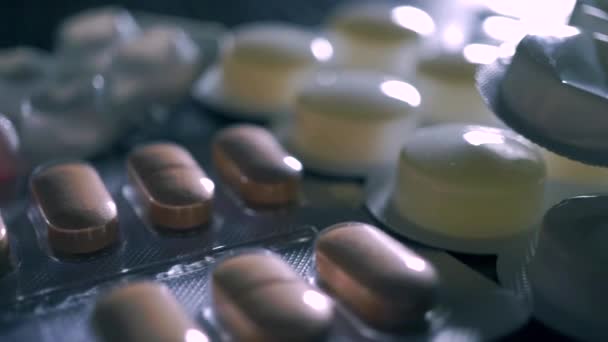 Different drug blister packs on black table macro pan shot — Stock Video