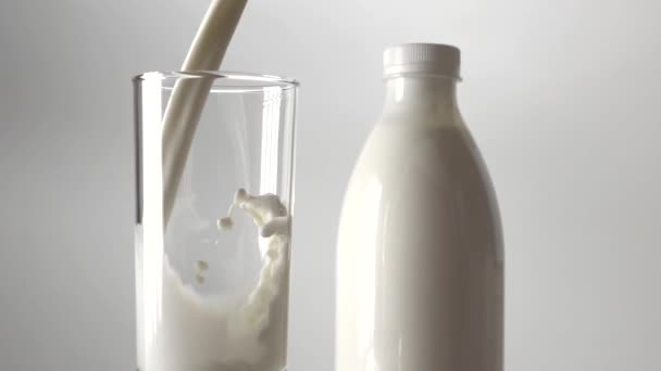 Se vierte una botella de leche y leche en un vaso. Super cámara lenta de vídeo — Vídeo de stock