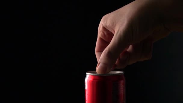 男は、泡沫状のコーラ缶を開きます。黒の背景にスローモーション撮影 — ストック動画