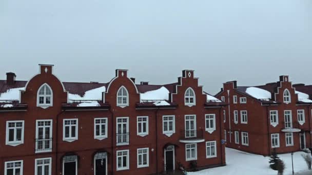 Schnee gegen rote Backsteinhäuser Super-Zeitlupenaufnahme — Stockvideo