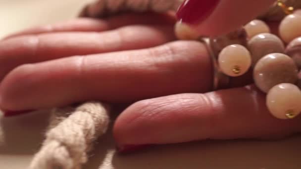 ベージュのネックレスを持つ美しい女性の手クローズ アップ ショット — ストック動画