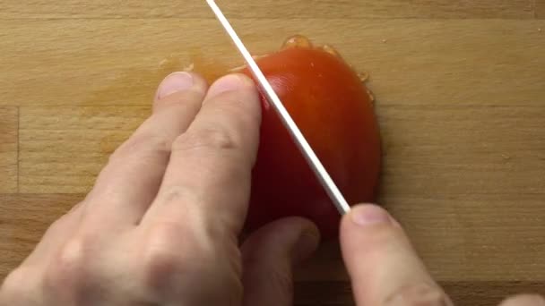 Fazendo salada de legumes: cortando tomate vermelho na tábua de corte. 4K close up de vídeo — Vídeo de Stock