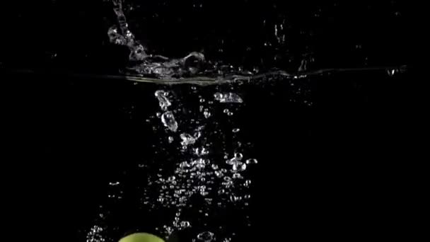 Super slow motion shot: falling juicy green apples and splashes of water — Stock Video