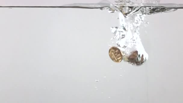 Video super slow motion di monete multiple che affondano in acqua. Concetto di crisi — Video Stock